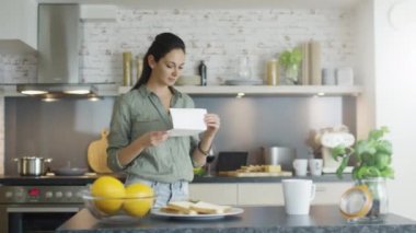 Mutfak genç kız mektup ve Gets çok iyi bir haber izlerken. Gerçekten mutlu.