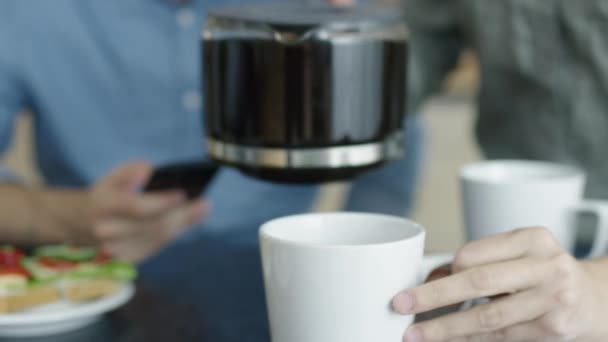 Primer plano de una mujer vertiendo café de la cafetera para dos . — Vídeos de Stock