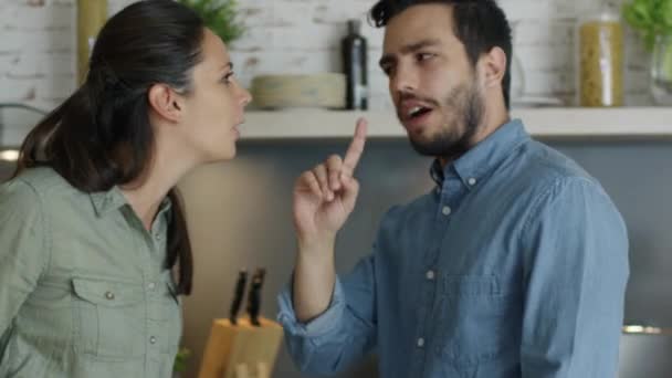 Jong (echt) paar ruzies in de keuken. Man en vrouw schreeuwen in frustratie en boos zwaaien. — Stockvideo