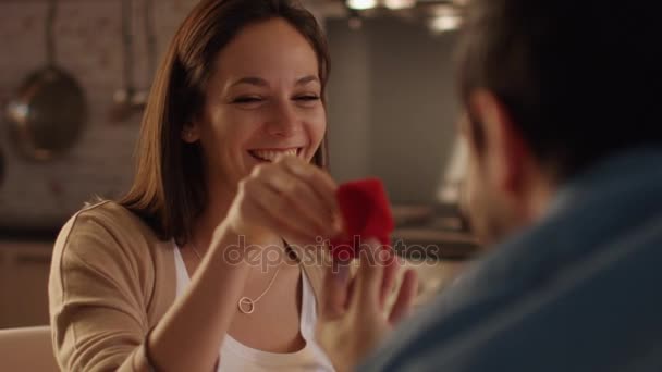 Close-up de uma linda menina aceitando proposta. Ele abre a caixa de anel para ela ela pega o anel e tenta em seu dedo . — Vídeo de Stock