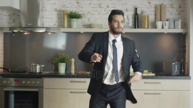 Klas ve yakışıklı genç işadamı dansları enerjik onun mutfak at.