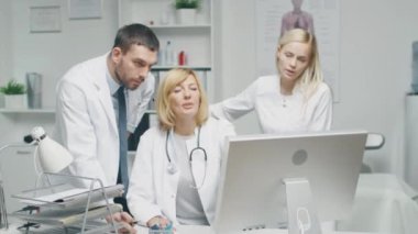 Tıbbi personel tartışmak iş ilgili sorunları kişisel bilgisayar kullanarak tamamlayın. Erkek doktor Puan ekranında.