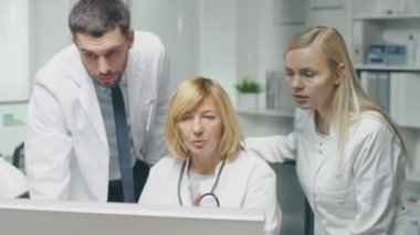 Tıbbi personel tartışmak iş ilgili sorunları kişisel bilgisayar kullanarak tamamlayın. Erkek doktor Puan vasıl belgili tanımlık perde. Onlar sözleşmesinde başını sallamak.