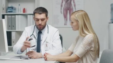 Doktor ofisinde. Pratik doktor verir kutu ilaç onun güzel sarışın Bayan hasta için reçete.