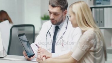 Onun kadın hasta Tablet bilgisayarınızla bu röntgende doktor gösterir. Ağır çekimde.