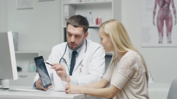 Arts toont aan zijne vrouw patiënt tabletcomputer met X-Ray op het. — Stockvideo