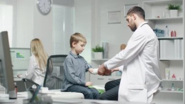 Bandaj genç oğlanın elini doktor.