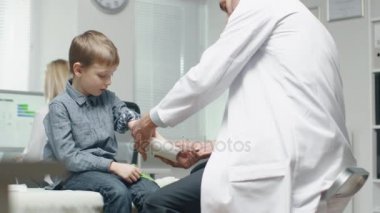 Erkek doktor kaldırır sıva bir çocuktan el iyileşti. Çocuk çok mutlu olduğunu .