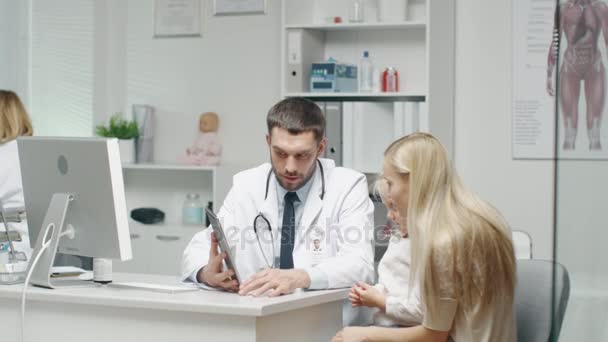 "Erkek doktor genç kız ve annesi bir Tablet yardımıyla danışır. Onlar sıcak gülümseme. " — Stok video