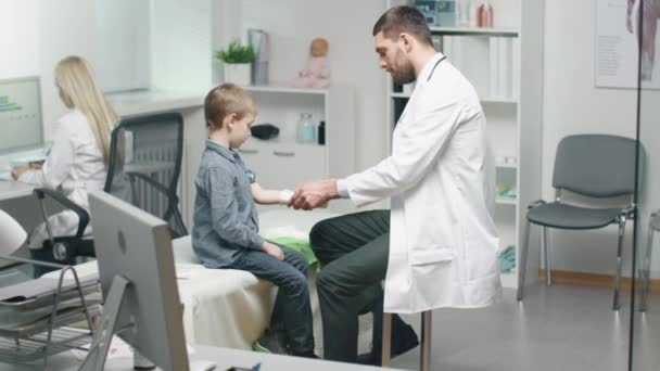 Mannelijke arts verwijdert gips van een jongen de Hand genezen. Jongen is erg blij. Ze doen High Five. — Stockvideo