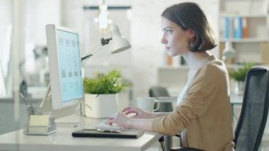Onun masaüstü bilgisayarda tasarımı yaratıcı esmer. Onun geliştirme ofis oturma.