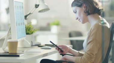 Aydınlık ve Modern ofisinde otururken güzel esmer kullanır Smartphone.