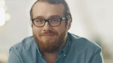 Mutlu genç Ginger gözlük gülümsemek kameraya giyen adam sakallı. Parlak ışıklar içinde belgili tanımlık geçmiş.