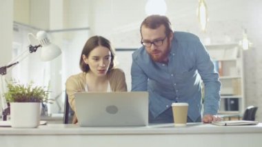 Portre çekim bir erkek ve bir kadın Streight kameraya bakarak iş tartışıyor. Parlak yaktı Modern ofis içinde.