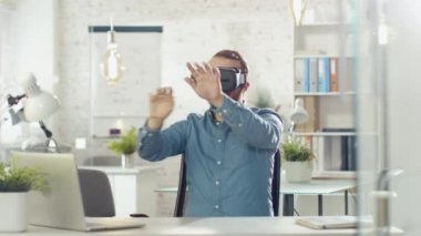 Yaratıcı genç geliştirici kullanan sanal gerçeklik onun ofisinde O'nun masasında otururken gözlük.