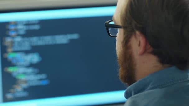 Close-up of a Man's Head in the Background Computer Screen with Code Line is Seen. — Stock Video