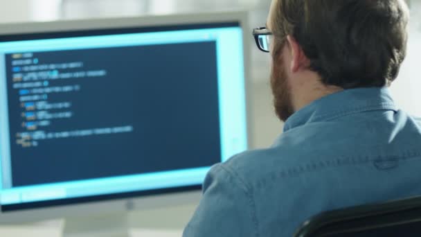 Shot From Behind of a Bearded Young Developer Writing Code on His Computer. — Stock Video