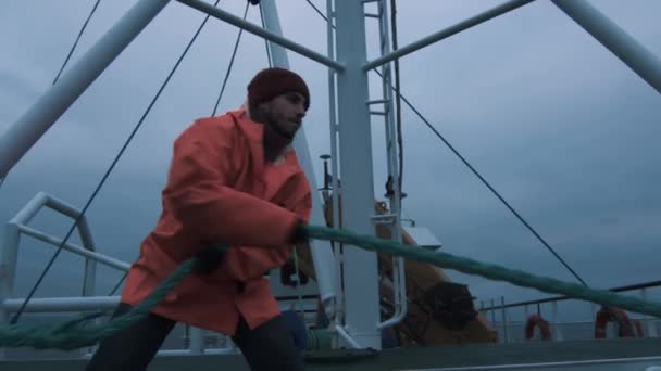 Ernsthafter Matrose zieht während der Schiffsreise das dicke Seil — Stockvideo