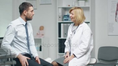 Yetişkin kadın doktor onun sırt ağrısı hakkında genç adam danışır.. 