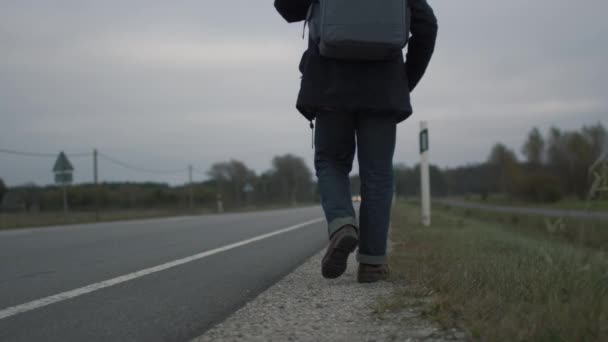 Casualy Dressed Traveler Sitting by the Highway at a Cloudy Day. — Stock Video