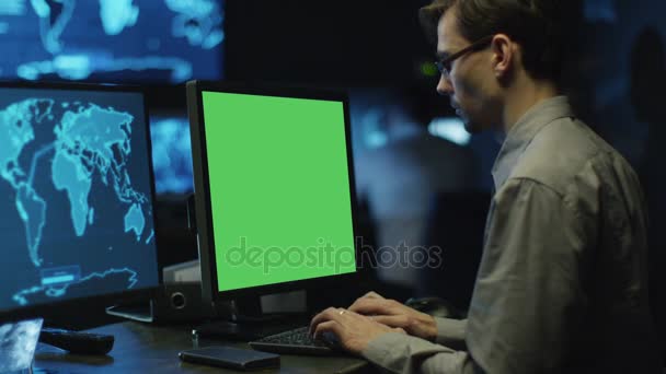 Los programadores concentrados trabajan en computadoras personales ubicadas en una sala de control del sistema. Computadora tiene pantalla verde . — Vídeos de Stock