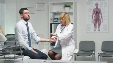 Yetişkin erkek doktor orta el ile erkek hastanın nabzı bakar.