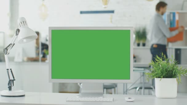 Primo piano di uno schermo verde su un personal computer. In background sfocato e luminosamente illuminato ufficio in cui le persone passano attraverso routine Office . — Video Stock