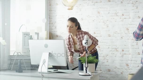 Mulher bonita caminha através do escritório criativo onde homem e mulher trabalham com quadro branco e computadores . — Vídeo de Stock