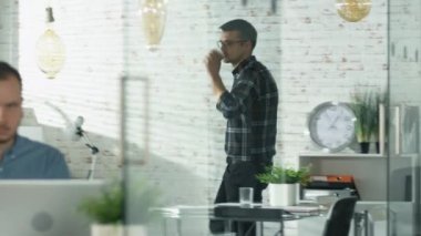 Dostum bir ofisine girecek ve kahve yudumlarken oturur onun işyerinde. Bir kişisel bilgisayar üzerinde çalışmaya başlar. Ön plan adam inşaat üstünde masasında oturan bir laptop.