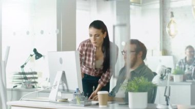 Bir meşgul ofis güzel kız yaklaşımlar Her erkek meslektaşı kim O'nun masasında oturan ve O'nun ekranda bir şey noktalarda, bu meseleyi görüşmek. Modern parlak ise.