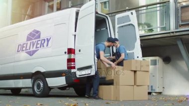 İki Movers gülümseyen bir Modern şehir karton kutular ile kargo Van yükleme vardır.
