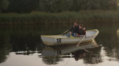 Baba ve oğul tekne oturuşta ve balık vardır.