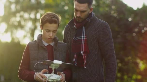 Padre e hijo usando control remoto de drones en el parque — Vídeos de Stock