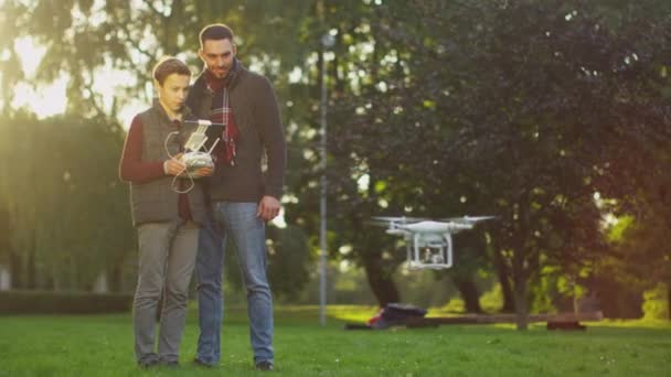 Zoon besturingselementen Drone vliegen terwijl vader horloges. In het Park. — Stockvideo