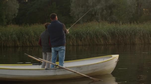 Padre e hijo están de pie en el barco y la pesca . — Vídeos de Stock