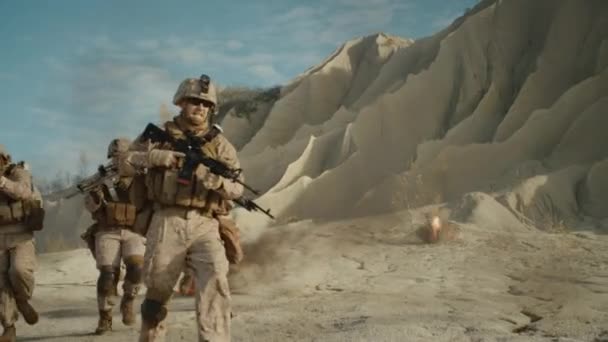 Escuadrón de soldados armados completamente equipados que corren y atacan durante la operación militar en el desierto. Moción lenta . — Vídeo de stock