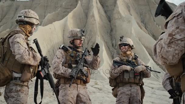 群士兵正站在一圈和听力的订单从指挥官期间简报之前在沙漠中的军事行动。慢动作. — 图库视频影像