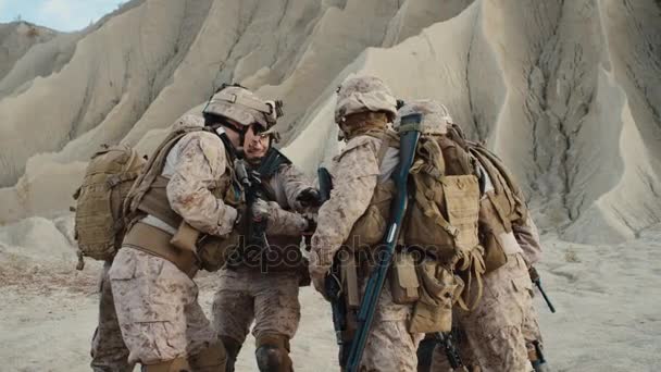 组的士兵正站在一个圆圈和铆合手作为符号的团队在年底前在沙漠中的军事行动简报。慢动作. — 图库视频影像