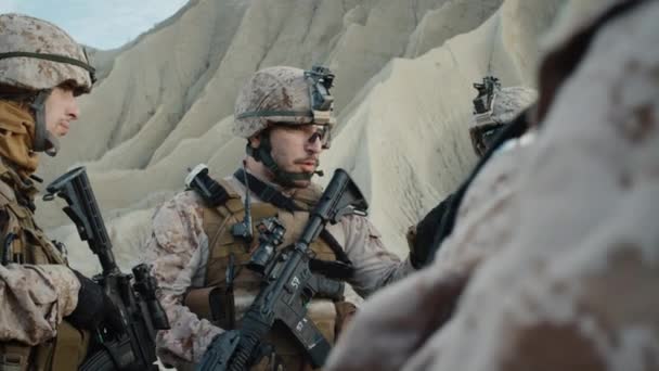 Le Groupe de soldats est debout dans un cercle et écoute les ordres du commandant lors d'une séance d'information avant l'opération militaire dans le désert. Mouvement lent . — Video