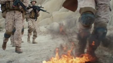 Yakın çekim Shot yere çölde yanan üzerinde yürüyen askerler. Ağır çekim.