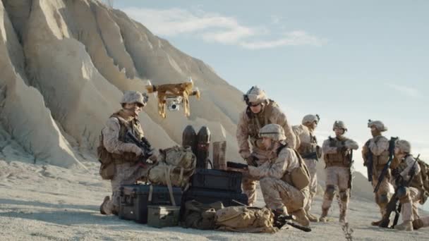 Los soldados están usando aviones no tripulados para explorar durante la operación militar en el desierto. Moción lenta . — Vídeos de Stock