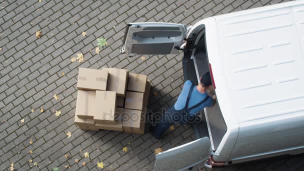 Entrega homem carrega sua van comercial com caixas de papelão . — Vídeo de Stock