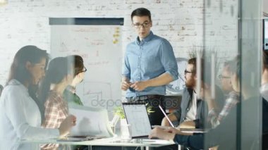 Yaratıcı Office ekibi beyaz tahta sunu kılıyor. İş arkadaşlarınızla açık dizüstü bilgisayarlar ile büyük cam masada otur. Şık ve parlak ofisidir. Ağır çekim.