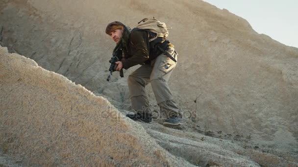 Terrorista armado caminando en medio del desierto — Vídeos de Stock
