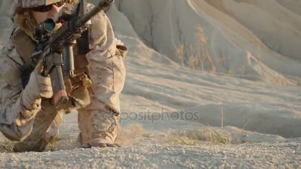 兵士は砂漠環境でアサルト ライフル スコープを丘の上に横たわって。スローモーション. — ストック動画