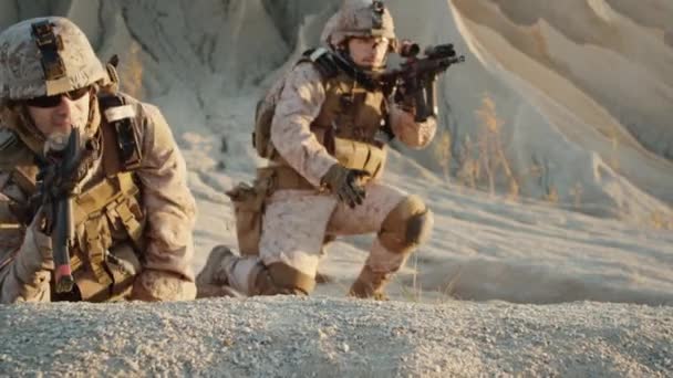 Csoport katonák hazugság le a hegyen, célja a támadás puska szálakon sivatagi környezetben. Lassú mozgás. — Stock videók