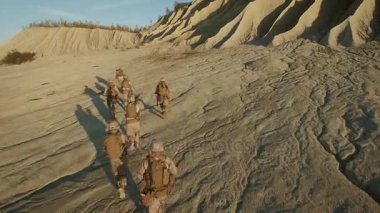 Grup çöl ortamında çalışan asker üzerinde uçan.