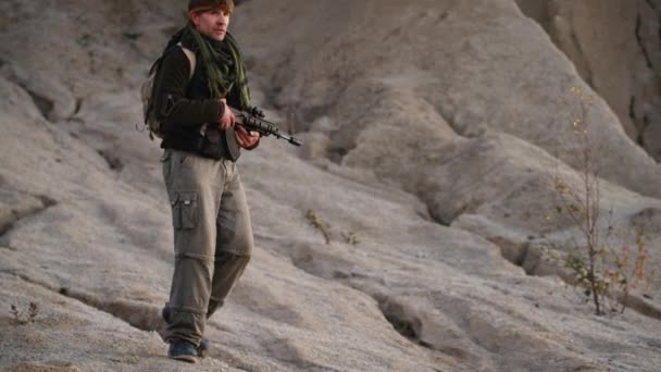 Вооруженные штурмовыми винтовками Террористы идут по пустынной местности . — стоковое видео