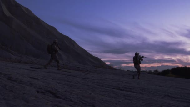 Grupo de soldados armados que corren durante la operación nocturna en el medio ambiente del desierto. Moción lenta . — Vídeos de Stock