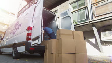 Genç hareket ettirmek onun ticari araç büyük karton kutuları ile yükler. 